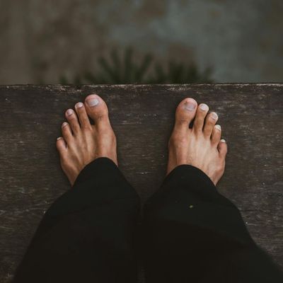 A person's feet on a wooden floor, suggesting stability and balance.